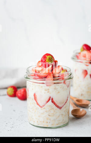 Petit-déjeuner sain du jour au lendemain de l'avoine avec des fraises et des cuillères en bois de bambou pour manger. Le petit-déjeuner végétarien, Végétalien Banque D'Images