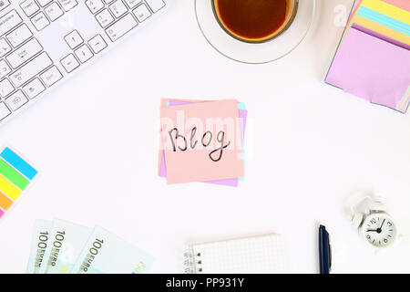 Blog de texte sur un autocollant note sur un bureau blanc à côté d'une tasse à café et d'un clavier. Vue de dessus, la mise en page Banque D'Images