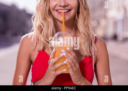 Young woman enjoying positive son jus d'orange Banque D'Images