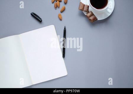 Fonds de l'étude. Arrière-plan de l'éducation. La papeterie. Aspects de l'éducation. La nourriture pour le cerveau. Marqueur ouvert, ordinateur portable ouvert, café, amandes et chocolat sur Banque D'Images