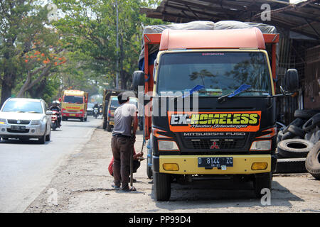 Les chauffeurs de camions et les travailleurs Contrôle des pneus à Bandung, Indonésie, Asie du sud-est. Banque D'Images