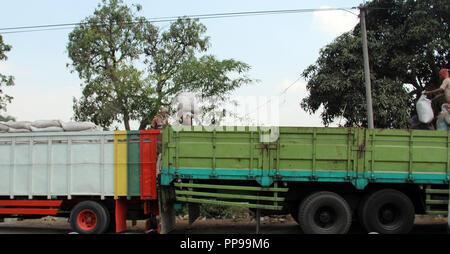 Les travailleurs du fret provenant de camions pour d'autres camions à Bandung, Indonésie, Asie du sud-est. Banque D'Images