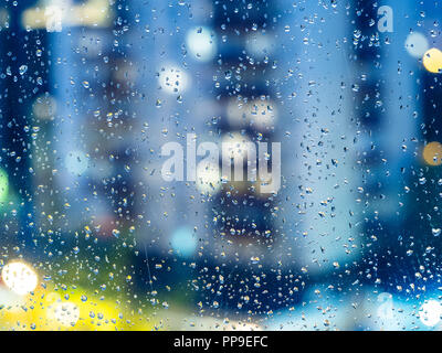 Automne pluvieux - voir des maisons urbaines à travers le trouble accueil fenêtre avec gouttes en soirée (l'accent sur les gouttes de pluie sur la vitre) Banque D'Images