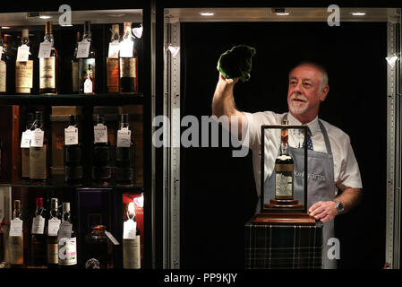 Danny McIlwraith de Bonhams nettoie le cabinet qui abrite le whisky le plus rare et le plus précieux du monde - une bouteille du Macallan Valerio Adami 60 ans 1926 avec une estimation de &livre;700,000-900,000. En prévision de la prochaine vente aux enchères de Bonhams à la maison de vente aux enchères d'Édimbourg, qui doit présenter le whisky le plus rare et le plus précieux au monde : une bouteille du Macallan Valerio Adami 60 ans 1926 avec une estimation de &livre;700,000-900,000. Banque D'Images