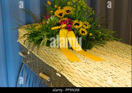 Un arrangement floral sur un cercueil tressé dans une morgue Banque D'Images