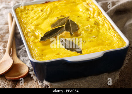 Bobotie sud africain épicé plat composé de viande hachée cuite au four avec un oeuf en fonction de la garniture dans un plat allant au four, sur la table. L'horizontale Banque D'Images