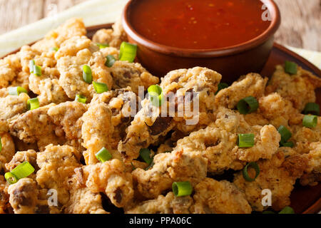 Dans l'estomac de poulet frit, pané servi avec sauce chili close-up sur une plaque horizontale. Banque D'Images