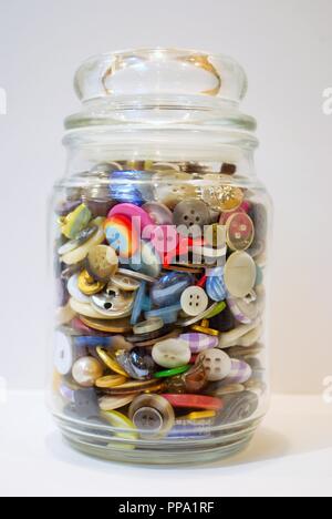 Pot plein de boutons multicolores débordant Banque D'Images