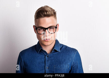 Portrait d'un certain jeune homme dans un studio, wearing blue shirt. Copier l'espace. Banque D'Images