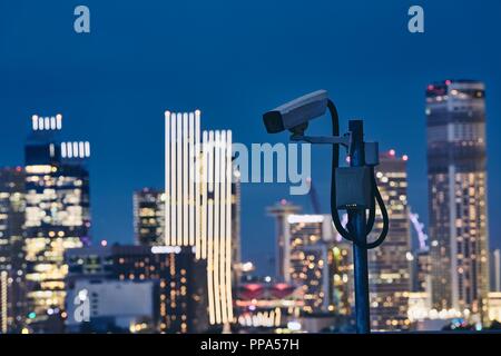 Caméra de sécurité contre l'allumé en paysage urbain de nuit. Concept de surveillance, de protection et de sécurité. Banque D'Images