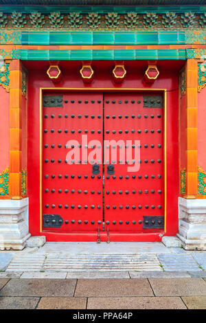 Porte en bois fleuri rouge avec garniture de tuiles traditionnelles et Chinise design à la Cité Interdite, à Pékin, Chine Banque D'Images