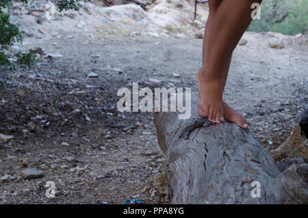 Fille de hippies marchant pieds nus sur un grand stump Banque D'Images