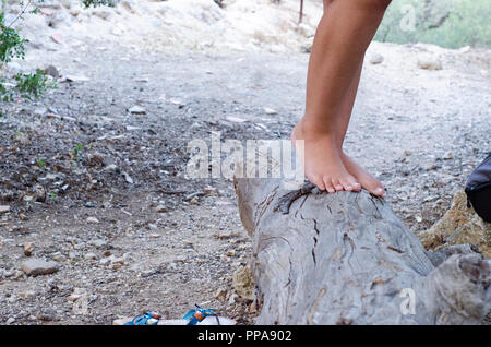 Fille de hippies marchant pieds nus sur un grand stump Banque D'Images