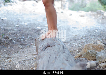 Fille de hippies marchant pieds nus sur un grand stump Banque D'Images