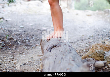 Fille de hippies marchant pieds nus sur un grand stump Banque D'Images