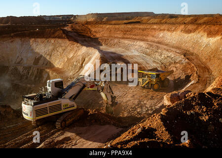 Les camions d'être chargé de minerai par digger en mine à ciel ouvert, l'ouest de l'Australie Banque D'Images