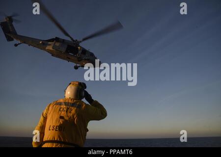 Océan (Aug. 29, 2018) Maître de Manœuvre 3 Classe Jauregui Gerardo, de Panorama City, en Californie, salue un hélicoptère MH-60S dans le poste de pilotage à bord du croiseur lance-missiles USS Vella Gulf (CG 72). Vella Gulf est actuellement en cours d'essais en mer dans l'océan Atlantique. Banque D'Images