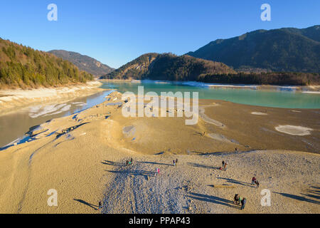 Lac de stockage dégonflé avec touristes en hiver, le lac de Sylvenstein, Isartal, Lenggries, Haute-Bavière, Bavaria, Germany, Europe Banque D'Images