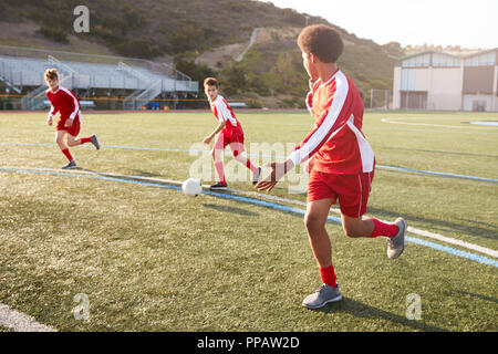 Groupe d'élèves du secondaire de sexe masculin jouant dans l'équipe de soccer Banque D'Images