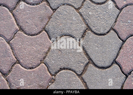 Bloc de ciment gris et rose sur le trottoir, le pavage de la rue, et la texture de fond de la dalle, on fixe le carrelage des trottoirs. Banque D'Images