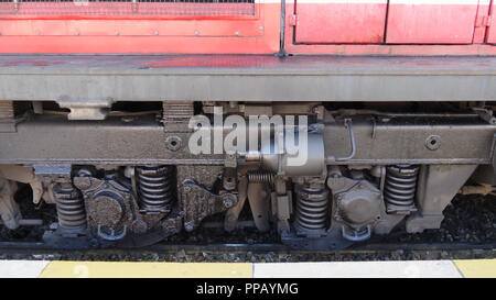 Train, locomotive diesel rouge, Close up detail de suspension, amortisseur et les roues de wagon de marchandises - autorail diesel Banque D'Images
