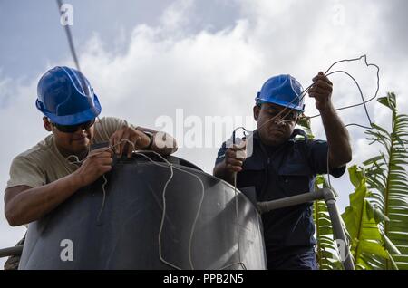 U.S. Air Force d'un membre de la 1re classe Christopher Gomez, 374e Escadron d'ingénieurs civils, Yokota, Japon, et Sir Lanka air force l'Aviateur-chef Somatnilana Ednisingne déposer un réservoir d'eau lors de l'école Ange du Pacifique (PAC) ANGEL 18-4 à Vavuniya, Sri Lanka, 14 août 2018. Les efforts entrepris au cours de l'aide militaires multilatérales ANGE PAC dans l'Indo-Pacifique d'améliorer et d'établir des relations dans un large éventail d'engagements civiques, qui renforce la capacité de chaque nation à répondre et à prendre en charge l'aide humanitaire et des opérations de secours. Banque D'Images