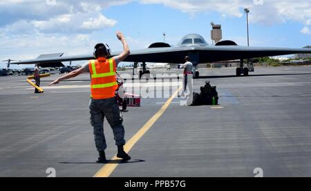 Un technicien de maintenance de l'US Air Force, déployés à partir de Whiteman Air Force Base, Alabama, marshals un B-2 Spirit au Joint Base Harbor-Hickam Pearl, Washington, 15 août 2018. B-2s font régulièrement des stages dans l'Indo-Pacifique pour mener des opérations aériennes, qui intègrent des capacités avec les principaux partenaires régionaux et de démontrer l'engagement des États-Unis pour la paix et la stabilité dans la région. Ces opérations sont à l'appui du Commandement stratégique américain Bomber's Task Force de déploiement. Banque D'Images