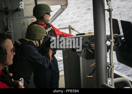 Océan Pacifique (août 13, 2018) l'Aviation Ordnanceman Sarsaba 3e classe Steve, de Chicago, une mitrailleuse M2HB au cours d'un exercice de tir réel sur la troupe tribord de la passerelle de débarquement amphibie USS Bonhomme Richard (DG 6). Bonhomme Richard est actuellement en cours aux États-Unis de la flotte de 3ème zone d'opérations. Banque D'Images