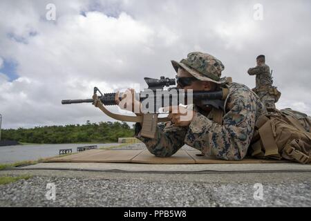Le Cpl. Justin Lara incendies dans la position ventrale pendant un cours d'entraîneurs de l'adresse au tir de combat au Camp Hansen, Okinawa, Japon, 14 août 2018. Lara, originaire d'Austin, Texas, et d'un fantassin du 2e Bataillon, 3e Régiment de Marines. "Je n'ai jamais touché un pistolet ou une carabine avant le Marine Corps," dit-il. "Je suppose que certaines personnes disent que c'est intéressant, ou bizarre, parce que je suis du Texas." Maintenant Lara apprend à être un entraîneur où il va former plus de 100 Marines américains par an, à la carabine et au pistolet de la compétence. Banque D'Images