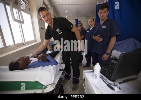 Le Major de l'Armée américaine Thomas Nessler, un médecin d'urgence, de Fort Hood, au Texas, offre une formation pratique avec la technologie des ultrasons mobiles aux États-Unis et au personnel médical rwandais au cours de MEDRETE 18-5 à l'hôpital militaire rwandais, Kigali, Rwanda, 14 août 2018. MEDRETE est un effort combiné entre le gouvernement rwandais et l'Afrique de l'armée américaine. MEDRETE 18-5 fait partie d'une série d'exercices de formation de préparation médicale que l'Afrique de l'armée américaine est prévue pour faciliter au sein de divers pays d'Afrique, et sert d'occasion pour les militaires en partenariat pour affiner et renforcer leur général surg Banque D'Images