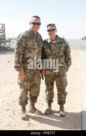 Le colonel de l'ARMÉE AMÉRICAINE Michael Maddox, le commandant de la base pour Al Asad Air Base, l'armée américaine accueille le brigadier. Le général Nikki Griffin Olive, commandant général du 335e, la commande Signal de bataille au cours d'une visite de rotation pour parler avec le personnel du signal et d'effectuer des visites de sites de signal services Al Asad Air Base, l'Iraq, le 15 août 2018. Banque D'Images