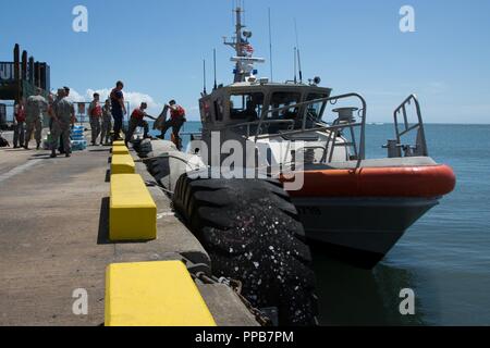 Aviateurs déployés dans le cadre des soins Tropic Maui County 2018 descendre d'un navire de la Garde côtière des États-Unis à Molokai, Hi., 12 août 2018. Soins Tropic 2018 Maui County Medical fournit des troupes et du personnel de soutien pratique à la formation de préparation pour préparer de futurs déploiements tout en offrant des avantages directs et durables pour la population de Maui, Molokai et Lanai. Banque D'Images