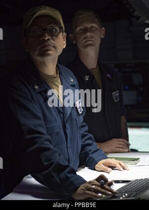 Mer (Aug. 21, 2018) Spécialiste des opérations de 2e classe Joseph Pacheco, gauche, et spécialiste des opérations 1re classe Jacob Smith se regarder dans le centre d'information de combat à bord de la classe Arleigh Burke destroyer lance-missiles USS Carney (DDG 64) 21 août, 2018. Carney, l'avant-déployé à Rota, en Espagne, est sur sa cinquième patrouille dans la sixième flotte américaine zone d'opérations à l'appui d'alliés et de partenaires régionaux ainsi que les intérêts de sécurité nationale des États-Unis en Europe et en Afrique. Banque D'Images