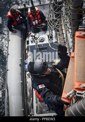 Mer (Aug. 25, 2018) Un garde-côte de Géorgie les conseils de classe Arleigh Burke destroyer lance-missiles USS Carney (DDG 64) pendant une visite, un conseil, une perquisition et saisie 25 août 2018 formation. Carney, l'avant-déployé à Rota, en Espagne, est sur sa cinquième patrouille dans la sixième flotte américaine zone d'opérations à l'appui d'alliés et de partenaires régionaux ainsi que les intérêts de sécurité nationale des États-Unis en Europe et en Afrique. Banque D'Images