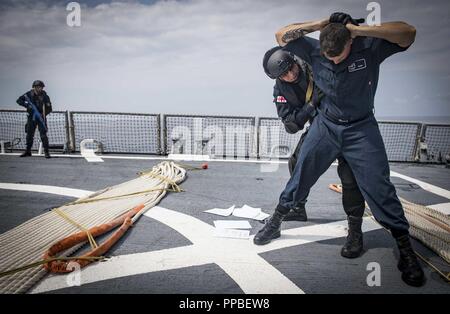 Mer (Aug. 25, 2018) Un garde-côte de Géorgie effectue une recherche de l'Artilleur 4400 Matelot Jordan Kennedy à bord de la classe Arleigh Burke destroyer lance-missiles USS Carney (DDG 64) pendant une visite, un conseil, une perquisition et saisie 25 août 2018 formation. Carney, l'avant-déployé à Rota, en Espagne, est sur sa cinquième patrouille dans la sixième flotte américaine zone d'opérations à l'appui d'alliés et de partenaires régionaux ainsi que les intérêts de sécurité nationale des États-Unis en Europe et en Afrique. Banque D'Images