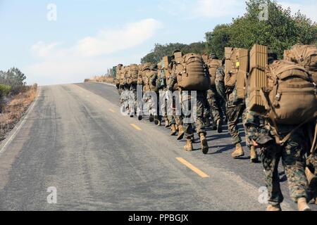 Les Marines et les marins avec le Siège et l'Escadron randonnée vers un champ de nuit mess côté principal Marine Corps Air Station Miramar, Californie, le 24 août. À la suite de l'4,5 mile randonnée H&HS a tenu une soirée d'honneur régimentaire en campagne l'héritage de Marines devant eux et à établir de bons dans l'escadron. Banque D'Images