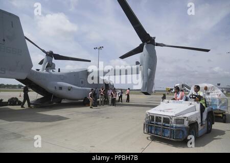 COLOMBO, SRI LANKA - matériaux sont portées à un MV-22 Osprey maritime avec l'escadron 166 à rotors basculants moyen renforcé, 13e Marine Expeditionary Unit (MEU), au cours d'un ravitaillement pour le groupe amphibie d'Essex (ARG) à l'aéroport international de Bandaranaike un centre logistique dans le cadre d'un déploiement de la Essex ARG et 13e MEU, le 28 août 2018. Le San Antonio-classe de transport amphibie USS dock Anchorage (LPD 23) et l'entrepris Marines de la 13e MEU a mené un exercice de coopération en matière de sécurité dans le théâtre avec la marine sri-lankaise et de la Marine de marine. Partie d'une U.S.-Sri Lanka Banque D'Images