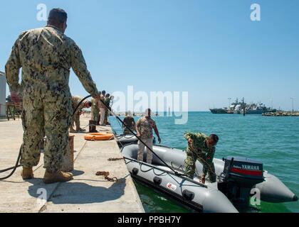 Premier maître de Manœuvre Robert Roy, de Blackfoot, Idaho, affecté à un groupe de rivière côtière (CRG) 1 Det. Guam, supervise les opérations de bateau fait par des membres de la Police nationale du Timor-Leste et la Force de défense du Timor-Leste Timor-Leste 2018 carats pendant à Hera Base Navale, le 28 août 2018. CARAT Timor-Leste 2018 est conçu pour répondre aux préoccupations de sécurité maritime commune, construire des relations et d'améliorer l'interopérabilité entre les forces canadiennes participantes. Banque D'Images