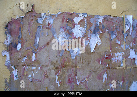 La décoloration et l'écaillage de la peinture et du papier sur le mur de plâtre en Italie Banque D'Images