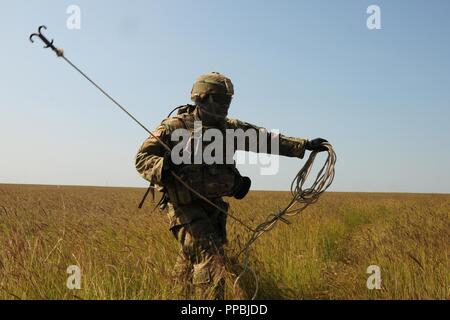 Circuit de l'armée américaine. Oghene Ejefiavwo, ingénieur de combat affecté à la 91e bataillon du génie attaché à la 2e Bataillon, 5e régiment de cavalerie, 1st Armored Brigade Combat Team, 1re Division de cavalerie jette un grappin pour effacer un barbelé pendant une mission de tir réel à Galati, Roumanie Zone d'entraînement, le 29 août 2018. Les soldats du bataillon sont déployés à l'Europe en faveur de la résolution de l'Atlantique, un exercice d'entraînement durables entre l'OTAN et des forces américaines. Banque D'Images