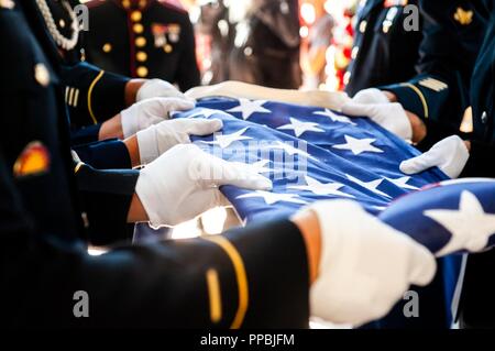 Membres d'une commission mixte sur la garde d'honneur composée de soldats, marins, aviateurs et marines, effectuer un pliage du drapeau lors de la cérémonie d'un service commémoratif organisé par le manque en Amérique (MIA) Projet au cimetière national de Willamette à Happy Valley, Oregon le 29 août. Le but de la MIA est de localiser, identifier et les vestiges de crémation non réclamés des anciens combattants américains grâce aux efforts conjoints du secteur, de l'état et les organismes fédéraux. Le projet a identifié 3 959 MIA cremains vétéran à date. (La Garde nationale de l'Oregon Banque D'Images