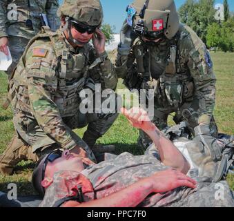 Circuit de l'armée américaine. Jasmine des Comeaux (à gauche) un combat medic affectés au quartier général de l'Administration centrale et compagnie, 2e bataillon du 5e régiment de cavalerie, 1st Armored Brigade Combat Team, 1re Division de cavalerie explique les faux blessés blessures aux États-Unis U.S. Army Sgt. Grayson Harris (droite) l'evasan medic à la base aérienne de Mihail Kogalniceanu en Roumanie, le 20 août 2018. Soldats Tableau VIII Medic, Validation des compétences un événement annuel de formation requis pour les soldats à garder leur qualification de spécialité militaire comme un combat medic. Banque D'Images