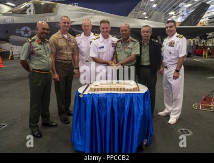 KINABALU (Août 20, 2018) - U.S. Navy Adm arrière. Joey Tynch, commandant de la Task Force 73, et le Major-général malaisien Dato Zulkapri, chef de délégation, les forces armées malaisiennes, posent pour une photo de groupe pendant le découpage tout en participant à la préparation et la formation de la coopération à flot (CARAT) 2018 la réception. CARAT la Malaisie, dans sa 24e version, est conçu pour accroître l'échange d'information et de coordination, de bâtir la capacité de combat de mutuelle et favoriser à long terme la coopération régionale permettant aux deux forces armées partenaire d'opérer efficacement ensemble comme une force maritime unifié. Banque D'Images