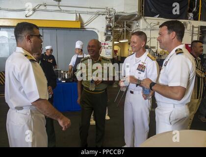 KINABALU (Août 20, 2018) - Le Capitaine de vaisseau américain Brian Mutty, commandant, Wasp-classe d'assaut amphibie USS Essex (DG 2), parle avec le Major-général Dato Zulkapri, chef de délégation, les forces armées malaisiennes, arrière de l'US Navy Adm. Joey Tynch, commandant de la Task Force 73, et Américains Frégate. Bradley Coletti, directeur général de l'Essex, au cours de la préparation et de la formation Coopération à flot (CARAT) 2018 la réception. CARAT la Malaisie, dans sa 24e version, est conçu pour accroître l'échange d'information et de coordination, de bâtir la capacité de combat de mutuelle et d'appui régional à long terme cooperat Banque D'Images