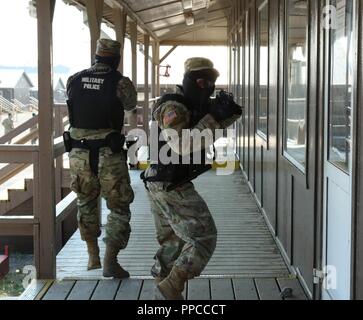 La CPS. James Mason Jr., centre et en circuit. Jacob Smith, répondre à une simulation de tir à l'actif de la salle à manger au Camp Bondsteel, Kosovo, 23 août. L'équipe de patrouille a éliminé la menace de prise de vue, au cours d'une évaluation l'événement de formation et a contribué à faciliter la coordination sur place d'autres organismes de première intervention. Banque D'Images