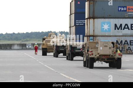 Employés avec le terminal à conteneurs en eaux profondes de route des véhicules militaires à une aire de rassemblement désigné, pour le 2e Escadron, 278e régiment de cavalerie blindée, une unité de la Garde nationale basée à Knoxville, Tennessee, dans le port de Gdansk, Pologne, le 28 août. La Pologne est l'un des quatre nations-cadre de l'OTAN pour l'amélioration de l'avant, la présence de l'Atlantique, une opération de résoudre la mission de formation de neuf mois pour réserver, Garde nationale et les unités de service actif avec les partenaires de l'OTAN dans l'engagement pour la paix, la sécurité et la stabilité en Europe. Banque D'Images