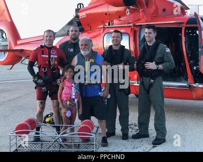 Membres de Coast Guard Air Station Atlantic City posent pour une photo avec un grand-père et sa petite-fille ils ont sauvé d'un brin motomarine à Grassy Sound, New Jersey, 31 août 2018. Les deux personnes portaient des gilets de sauvetage lorsque la motomarine s'est échoué. Banque D'Images