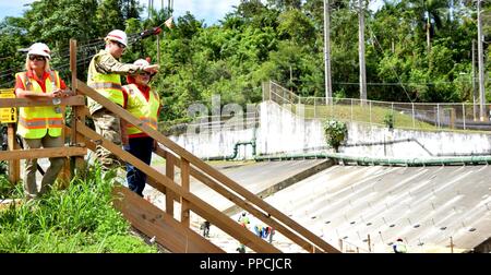 U.S. Army Corps of Engineers Task-force Recouvrement MAJ Commandant Scotty Autin (C) se dresse au sommet du barrage Guajataca, Isabela, Puerto Rico, 31 août 2018 construction en cours d'Guajataca provisoire du barrage de mesures de réduction des risques fournira un niveau de protection de 100 ans jusqu'au barrage et un niveau élevé de protection de l'année 1000 pour le déversoir et le canal. Banque D'Images