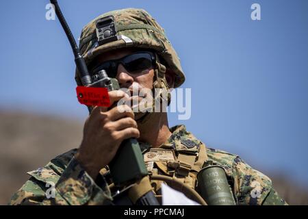 Corps des Marines des États-Unis 1er Sgt. Jorge Montes, première société Sergent, la Compagnie Charlie, 1er Bataillon, 4ème Marines, 1er Régiment de Marines, parle dans un PRC-152 radio pendant un assaut d'hélicoptères à la Marine Corps Base Camp Pendleton, en Californie, le 21 août, 2018. Les Marines ont été observés par des opérations expéditionnaires Training Group pour préparer correctement l'unité pour un prochain déploiement avec la 31e Marine Expeditionary Unit. Banque D'Images