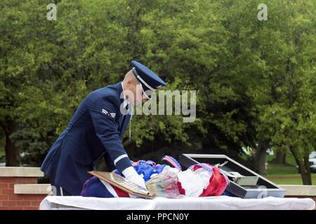 Zachary, Senior Airman Offutt Air Force Base, membre de la garde d'honneur, dépose une couronne de roses et à côté d'un morceau de l'épave d'60528 C-130, un avion qui a été abattu dans la guerre froide, au cours d'une cérémonie tenue le 30 août 2018, à Offutt Air Force Base, Nebraska. La cérémonie a été suivie par les membres de la 97e escadron du Renseignement, la piste de lavage, un groupe d'opérateurs ISR à la retraite, les membres de la famille et collègues ailier aux morts. Banque D'Images